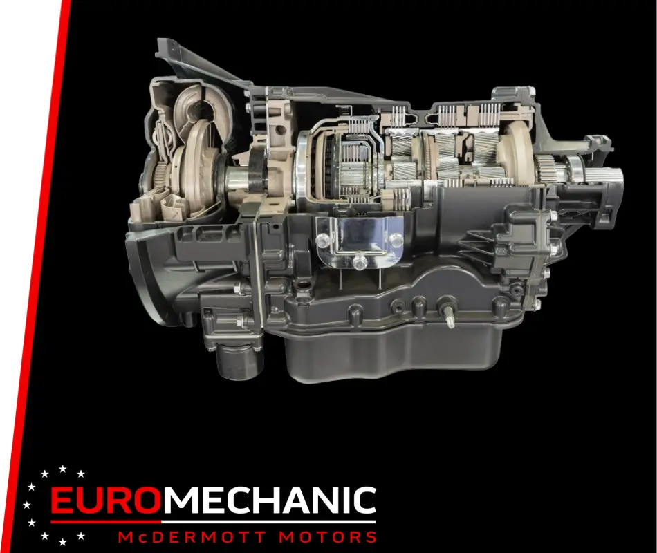 Cross-section of a car transmission system with exposed gears and components against a black background, illustrating the precision of transmission repair. The bottom left corner features the text Euromechanic McDermott Motors in white and red lettering. EuroMechanic | McDermott Motors Auto | Top Reviewed Auto Repair Shop in Toronto | Visit mcdermottmotors.com