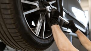 Mechanic comparing smaller wheels for winter tires during a seasonal tire change in Toronto